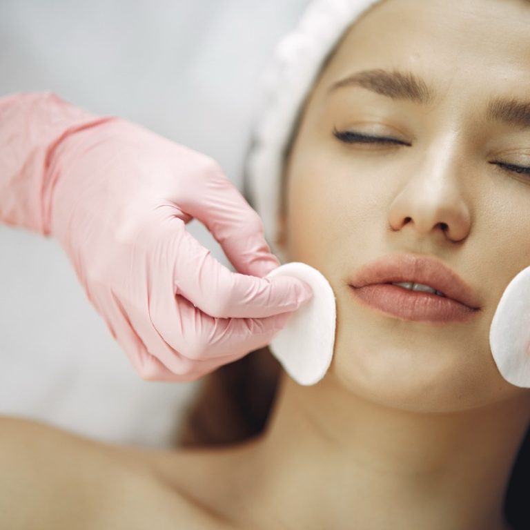 Cosmetologist treats client's skin. Woman with cosmetologist. Lady in a beauty studio.